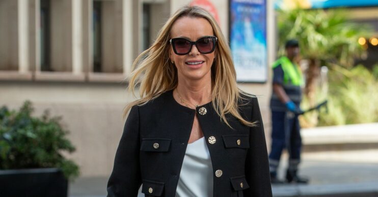 Amanda Holden wearing sunglasses and a black jacket walking