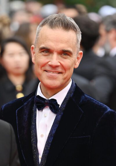 Robbie Williams smiling in a bow tie