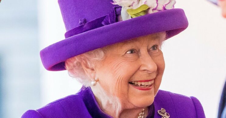 The Queen wearing purple and smiling